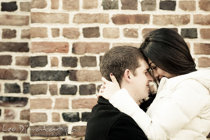 Engaged couple hugging close and smiling. City or urban setting pre-wedding or engagement photo session at Annapolis, by Annapolis wedding photographer, Leo Dj Photography.