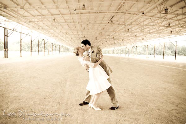 bride groom doing the dip, kissing under an abandoned warehouse structure. Annapolis Kent Island MD Modern Intimate Candid Posed Photojournalistic Style Wedding Photographer