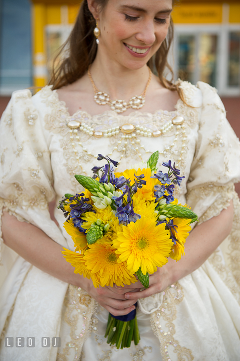 Bride holding her wedding floral bouquet from Divine Designs. Baltimore Maryland Science Center wedding reception and ceremony photo, by wedding photographers of Leo Dj Photography. http://leodjphoto.com