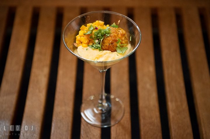 Close up detail shot of cocktail glass containing grits with corn and crabcakes on top from Aramark catering. Baltimore Maryland Science Center wedding reception and ceremony photo, by wedding photographers of Leo Dj Photography. http://leodjphoto.com
