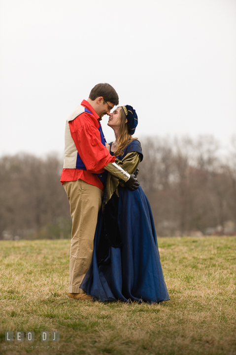 Engaged couple in a field laughing. Renaissance Costume Cosplay fun theme pre-wedding engagement photo session at Maryland, by wedding photographers of Leo Dj Photography. http://leodjphoto.com