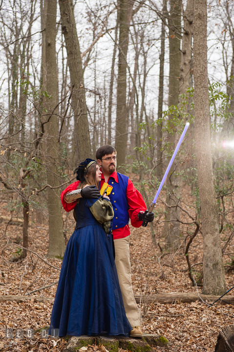 Engaged guy holding light saber and holding his fiancée. Renaissance Costume Cosplay fun theme pre-wedding engagement photo session at Maryland, by wedding photographers of Leo Dj Photography. http://leodjphoto.com