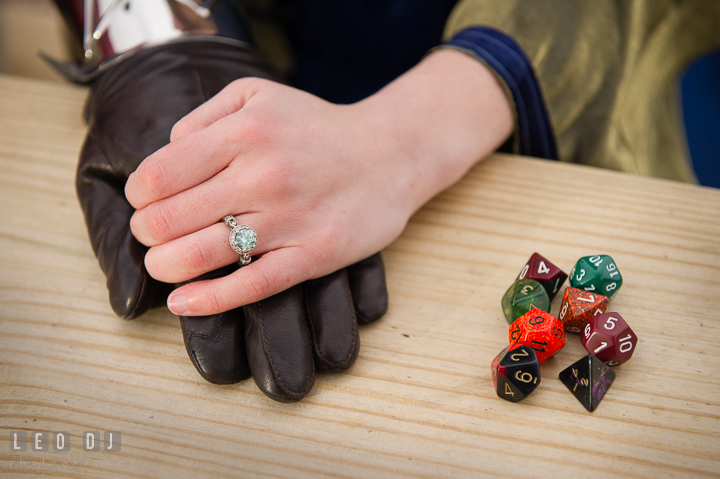 Engaged couple holding hands, showing engagement ring by Dungeons and Dragons dices. Renaissance Costume Cosplay fun theme pre-wedding engagement photo session at Maryland, by wedding photographers of Leo Dj Photography. http://leodjphoto.com