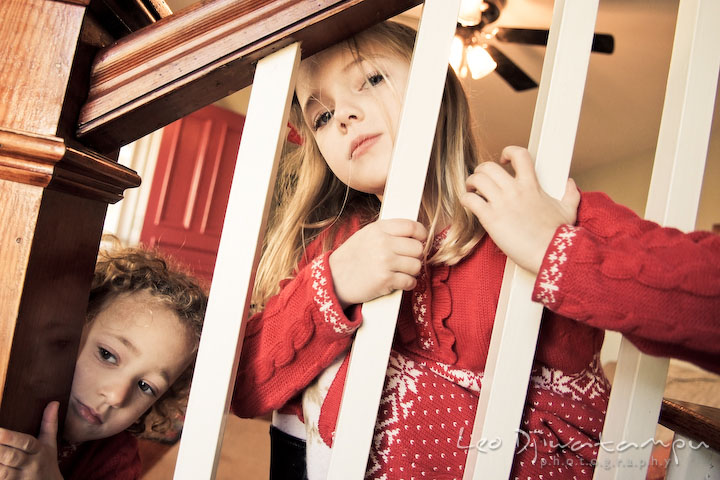 two sisters posing by stair railings. Candid children photographer St Michael Tilghman Island MD