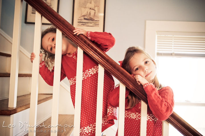 two cute girls posing on stair railings. Candid children photographer St Michael Tilghman Island MD