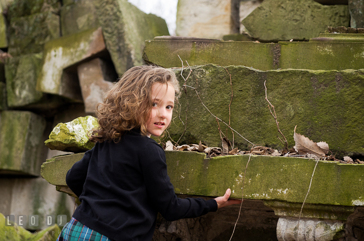 Girl climbing up wall ruins. Washington DC fun and candid children lifestyle photo session of Helena and Vivian by photographers of Leo Dj Photography.