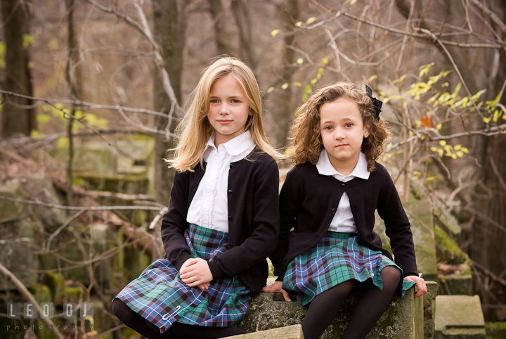 Two girls sitting on stone ruins. Washington DC fun and candid children lifestyle photo session of Helena and Vivian by photographers of Leo Dj Photography.