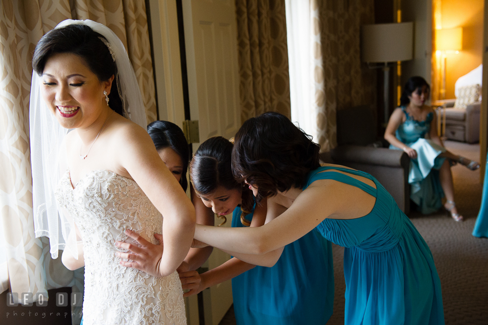 Sheraton Hotel Reston Virginia Bridesmaid helping Bride put on wedding gown photo by Leo Dj Photography