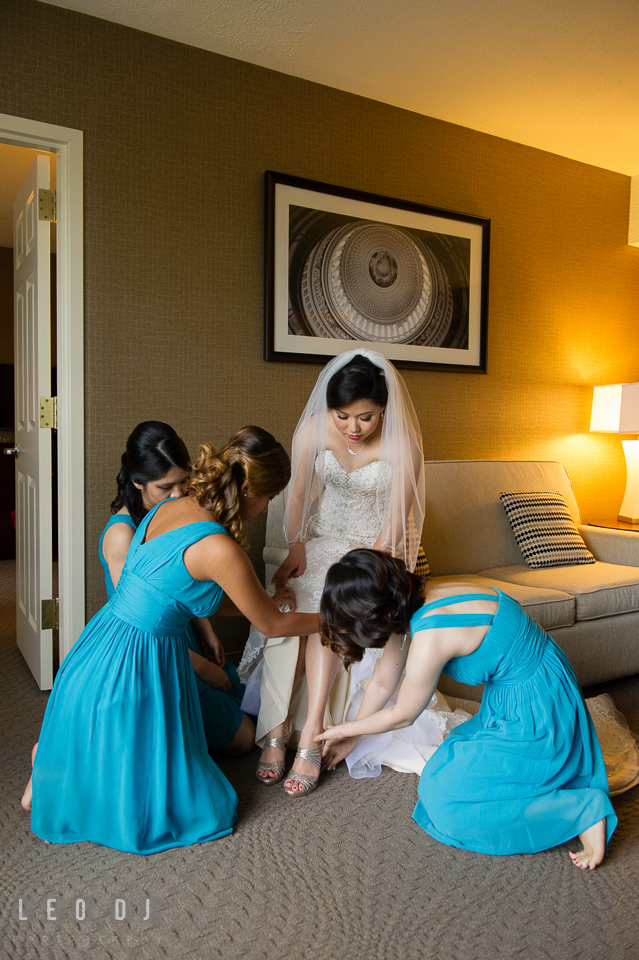 Sheraton Hotel Reston Virginia Bridesmaid helping Bride put on shoes photo by Leo Dj Photography