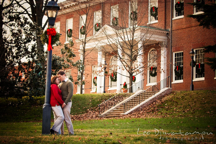 Engaged couple holding hands. Maryland State house with Christmas decorations. Urban city theme engagement session photographer Annapolis MD