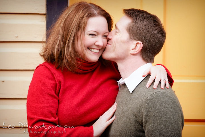 Engaged couple cuddling, laughing. Guy kissed girl. Urban city theme engagement session photographer Annapolis MD