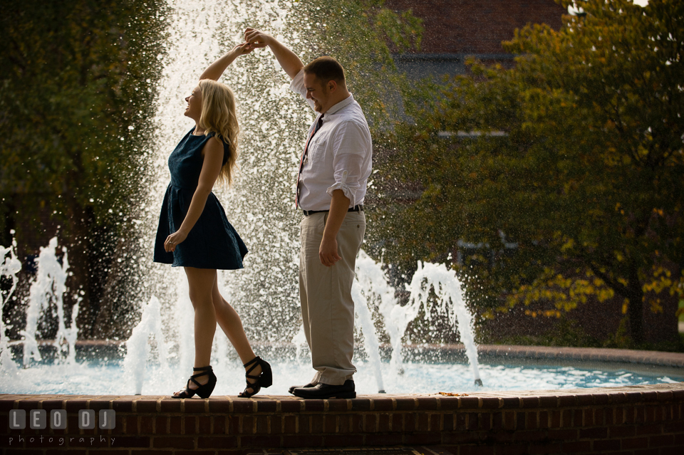 Engaged couple dancing and laughing by the water fountain. Gettysburg PA pre-wedding engagement photo session, by wedding photographers of Leo Dj Photography. http://leodjphoto.com