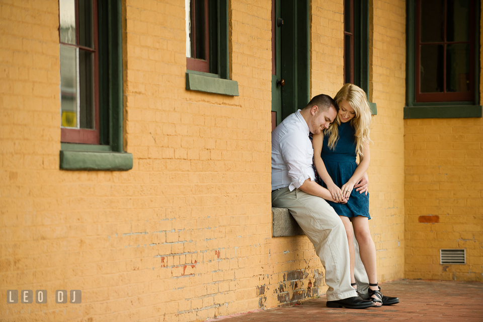 Engaged man and his fiancee cuddling by the train station. Gettysburg PA pre-wedding engagement photo session, by wedding photographers of Leo Dj Photography. http://leodjphoto.com