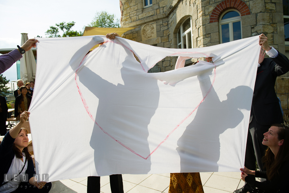 The Bride and Groom compete to cut out heart shape on a sheet of fabric. Landgrafen Restaurant, Jena, Germany, wedding reception and ceremony photo, by wedding photographers of Leo Dj Photography. http://leodjphoto.com