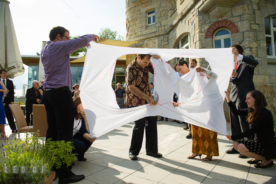 The Bride and Groom finishing quickly during the heart-cutting game on a sheet of fabric. Landgrafen Restaurant, Jena, Germany, wedding reception and ceremony photo, by wedding photographers of Leo Dj Photography. http://leodjphoto.com