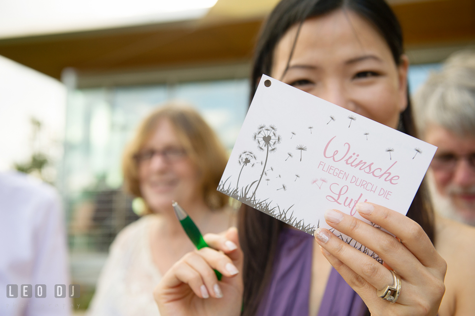 A guest showing the front of the postcard to be flown. Landgrafen Restaurant, Jena, Germany, wedding reception and ceremony photo, by wedding photographers of Leo Dj Photography. http://leodjphoto.com