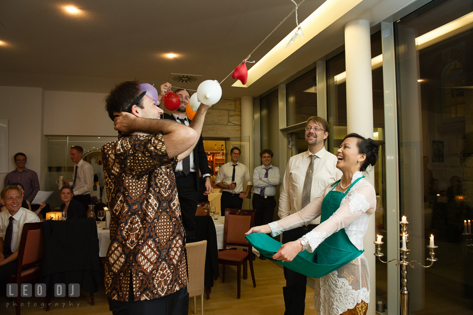 The Bride and Groom played popping the balloons game arranged by their friends during the wedding reception. Landgrafen Restaurant, Jena, Germany, wedding reception and ceremony photo, by wedding photographers of Leo Dj Photography. http://leodjphoto.com