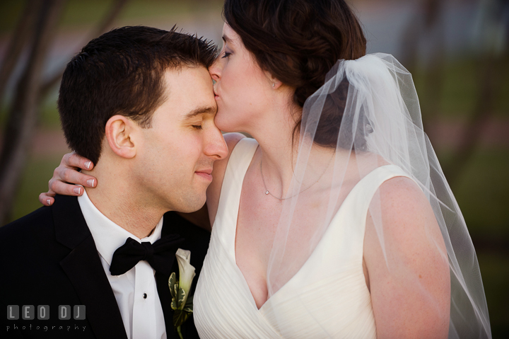 Bride kissing Groom's forehead at the United States Naval Academy campus. Historic Inns of Annapolis, Governor Calvert House wedding Maryland, by wedding photographers of Leo Dj Photography. http://leodjphoto.com