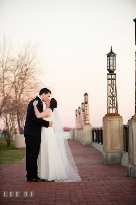 Bride and Groom along the waters of the US Naval Academy campus kissing. Historic Inns of Annapolis, Governor Calvert House wedding Maryland, by wedding photographers of Leo Dj Photography. http://leodjphoto.com