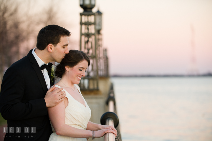 Groom kiss Bride while overlooking the water view at the US Naval Academy pier. Historic Inns of Annapolis, Governor Calvert House wedding Maryland, by wedding photographers of Leo Dj Photography. http://leodjphoto.com