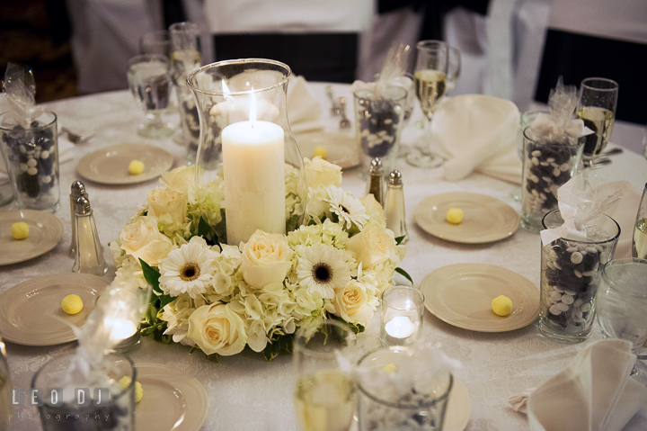 White flower table centerpiece with candle by Fantastic Flowers and M&M wedding favors. Historic Inns of Annapolis, Governor Calvert House wedding Maryland, by wedding photographers of Leo Dj Photography. http://leodjphoto.com