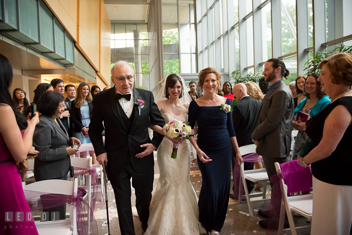 Bride walking down the isle during procession, escorted by Father and Mother of Bride. Falls Church Virginia 2941 Restaurant wedding ceremony photo, by wedding photographers of Leo Dj Photography. http://leodjphoto.com