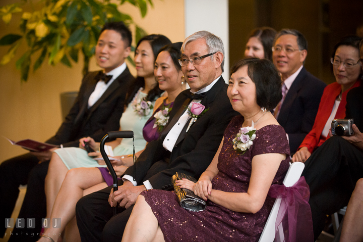 Groom's parents and siblings smiling listening to Bride and Groom's vows. Falls Church Virginia 2941 Restaurant wedding ceremony photo, by wedding photographers of Leo Dj Photography. http://leodjphoto.com