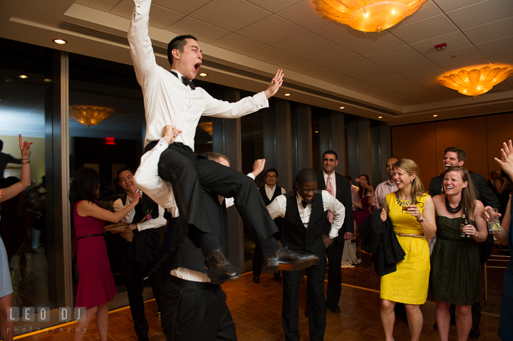 Groomsman carried Groom on his shoulder while dancing. Falls Church Virginia 2941 Restaurant wedding reception photo, by wedding photographers of Leo Dj Photography. http://leodjphoto.com