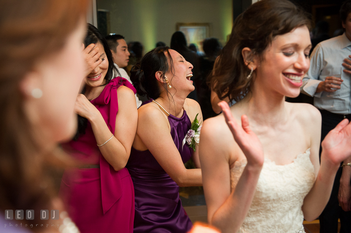 Groom's sister laughing hard while dancing. Falls Church Virginia 2941 Restaurant wedding reception photo, by wedding photographers of Leo Dj Photography. http://leodjphoto.com