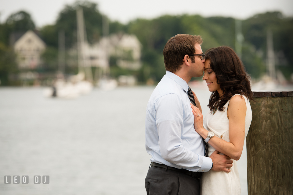 Engaged man on the dock kissed his fiancee on the forehead. Annapolis Eastern Shore Maryland pre-wedding engagement photo session at downtown, by wedding photographers of Leo Dj Photography. http://leodjphoto.com