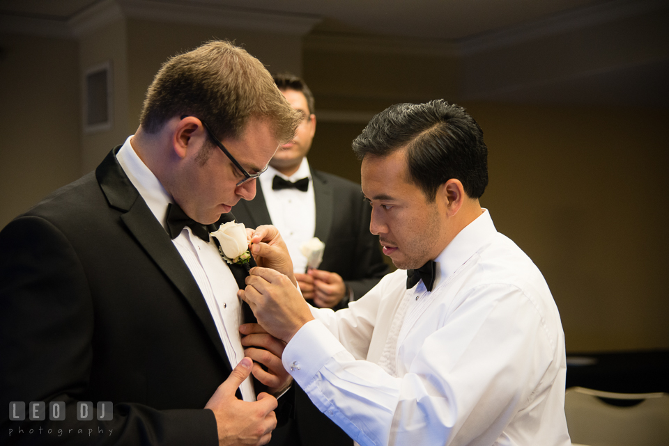 Groomsmen helping Groom put on boutonniere. Loews Annapolis Hotel Maryland wedding, by wedding photographers of Leo Dj Photography. http://leodjphoto.com