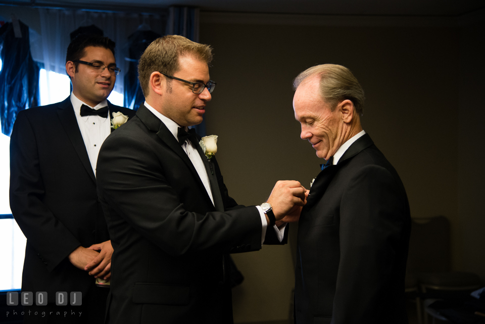 Groom helping Father of Bride put on boutonniere. Loews Annapolis Hotel Maryland wedding, by wedding photographers of Leo Dj Photography. http://leodjphoto.com