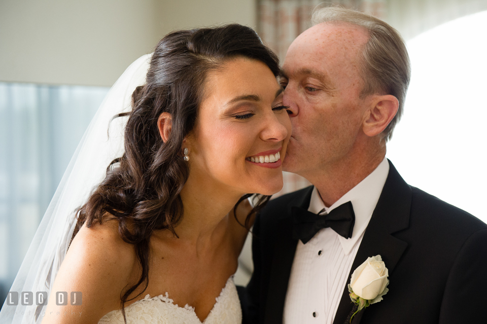 Father of Bride kissed daughter on cheek during first look with Dad. Loews Annapolis Hotel Maryland wedding, by wedding photographers of Leo Dj Photography. http://leodjphoto.com