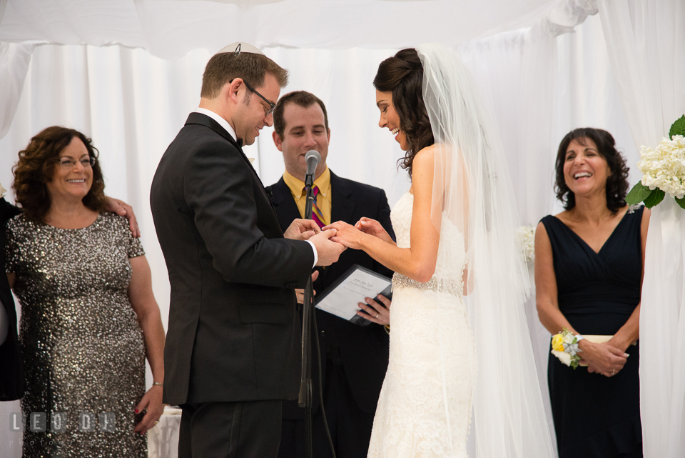 Mothers laughing as Groom reciting vows while put on ring for Bride. Loews Annapolis Hotel Maryland wedding, by wedding photographers of Leo Dj Photography. http://leodjphoto.com