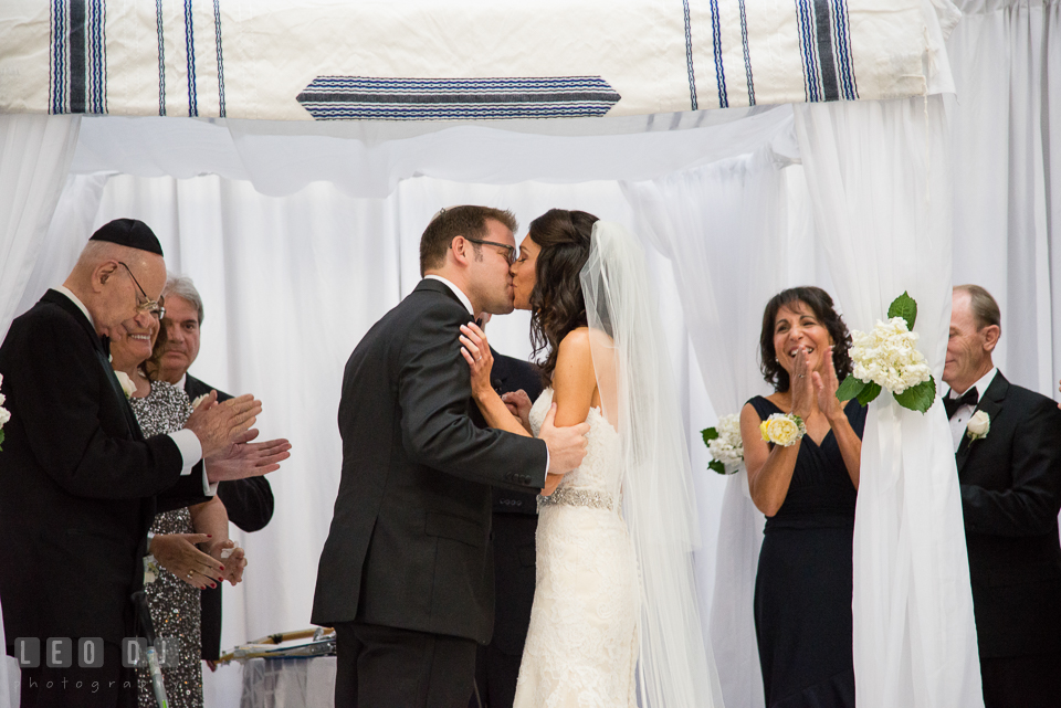 Bride and Groom first kiss under the chuppah during traditional Jewish ceremony. Loews Annapolis Hotel Maryland wedding, by wedding photographers of Leo Dj Photography. http://leodjphoto.com