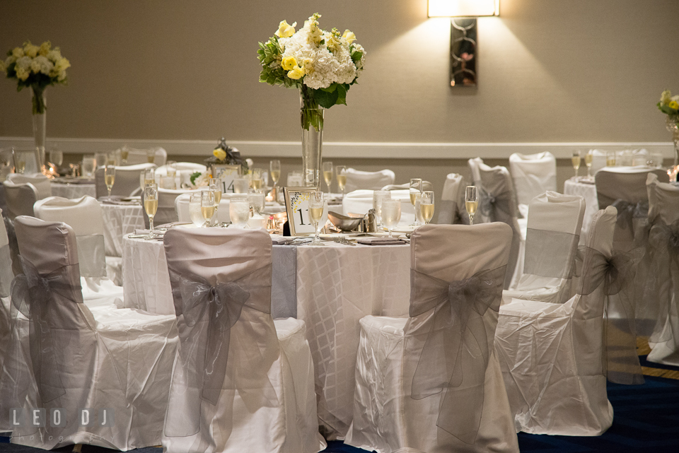 Dinning table setting with flower in tall vase centerpiece by Violets Florists by Connie Clark. Loews Annapolis Hotel Maryland wedding, by wedding photographers of Leo Dj Photography. http://leodjphoto.com