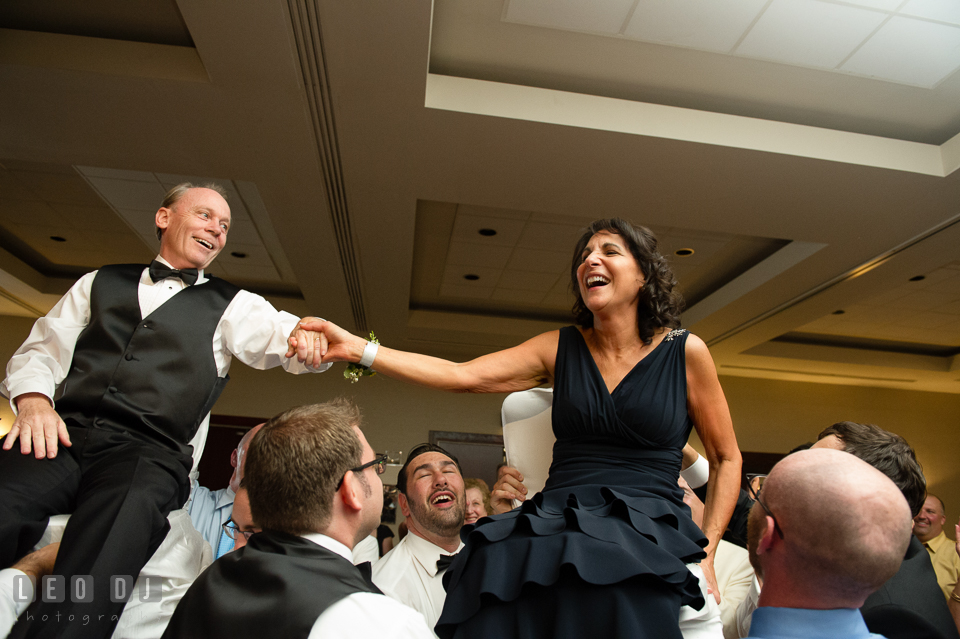 Father and Mother of Bride holding hands while raised up during Hora dance. Loews Annapolis Hotel Maryland wedding, by wedding photographers of Leo Dj Photography. http://leodjphoto.com