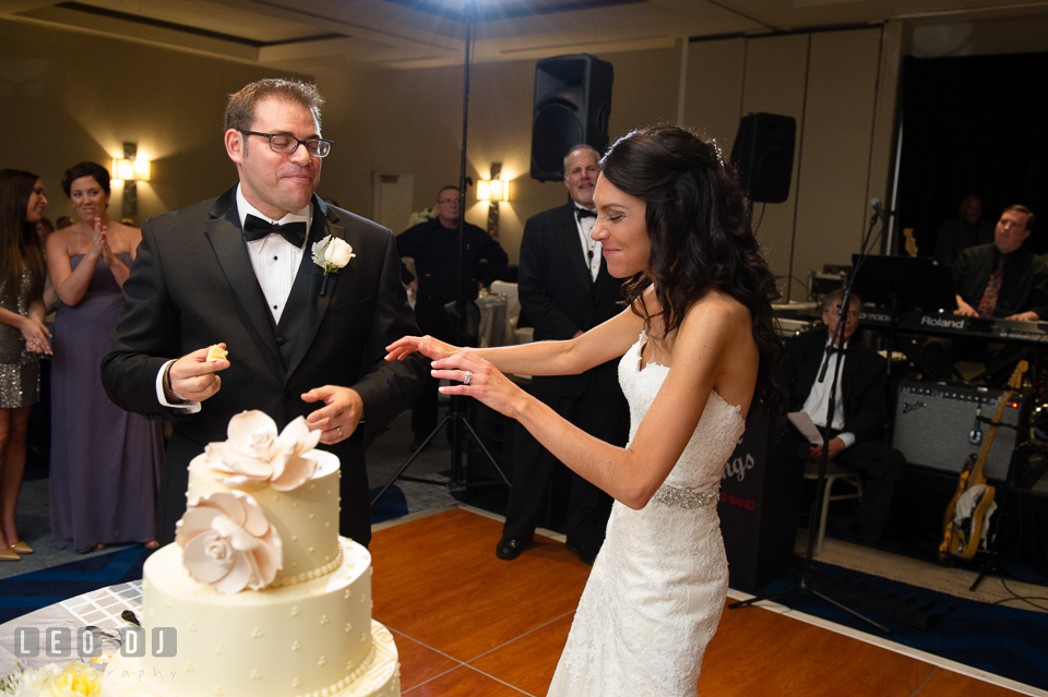 Bride and Groom teasing each other during cake cutting. Loews Annapolis Hotel Maryland wedding, by wedding photographers of Leo Dj Photography. http://leodjphoto.com