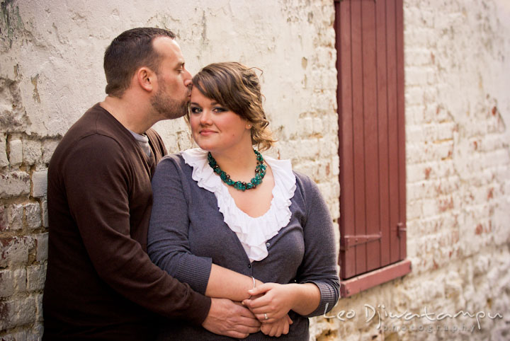 Engaged girl hugged and kissed by her fiancé. Pre-wedding or engagement photo session at Annapolis city harbor, Maryland, Eastern Shore, by wedding photographers of Leo Dj Photography.