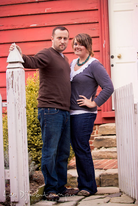 Engaged couple posing by a picket fence gate. Pre-wedding or engagement photo session at Annapolis city harbor, Maryland, Eastern Shore, by wedding photographers of Leo Dj Photography.