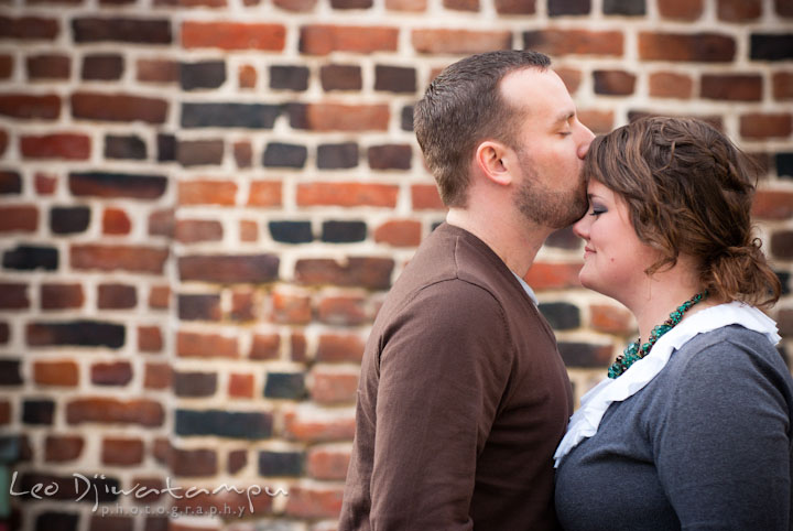 Engaged guy kissed his fiancée's forehead. Pre-wedding or engagement photo session at Annapolis city harbor, Maryland, Eastern Shore, by wedding photographers of Leo Dj Photography.