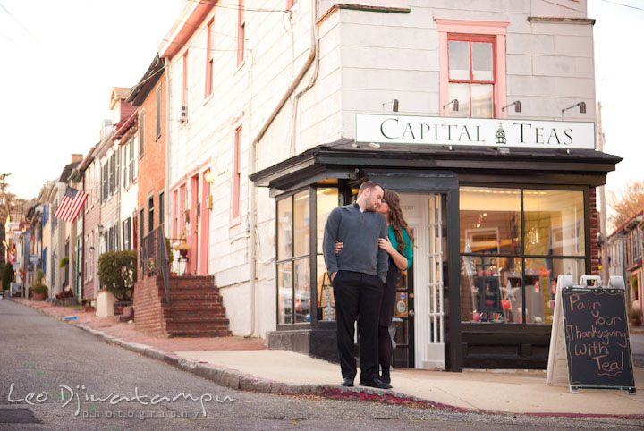 Engaged girl hugging her fiance in front of a tea shop. Pre-wedding or engagement photo session at Annapolis city harbor, Maryland, Eastern Shore, by wedding photographers of Leo Dj Photography.