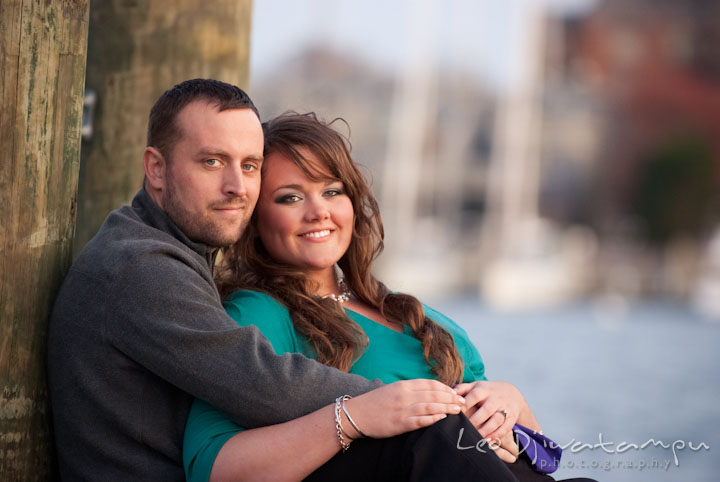 Engaged couple cuddling and smiling. Pre-wedding or engagement photo session at Annapolis city harbor, Maryland, Eastern Shore, by wedding photographers of Leo Dj Photography.