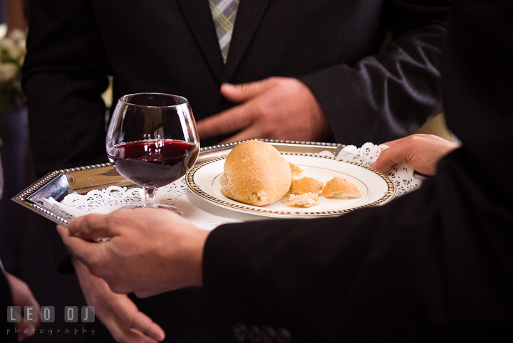 Communion of husband and wife with wine and bread. The Ballroom at The Chesapeake Inn wedding ceremony photos, Chesapeake City, Maryland by photographers of Leo Dj Photography.