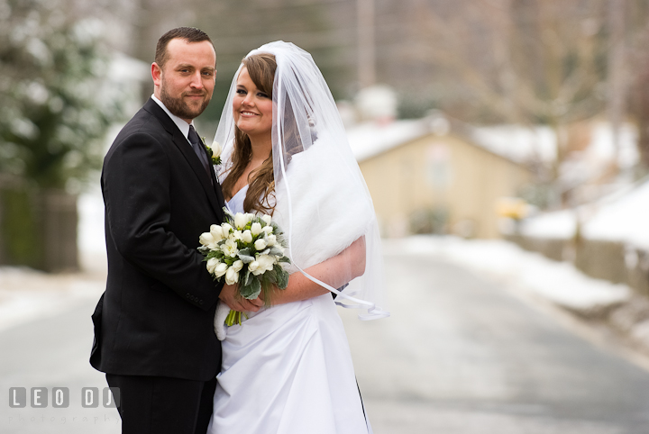 Bride and Groom posing on a road covered with snow. The Ballroom at The Chesapeake Inn wedding ceremony photos, Chesapeake City, Maryland by photographers of Leo Dj Photography.