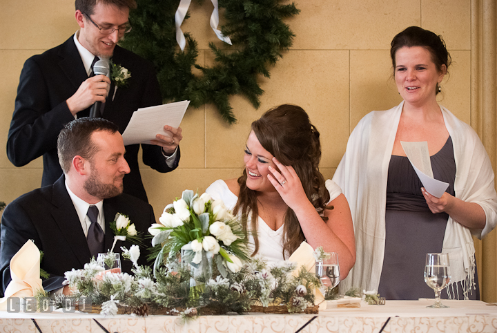 Bride and Groom laughing listening to Best Man's speech. The Ballroom at The Chesapeake Inn wedding reception photos, Chesapeake City, Maryland by photographers of Leo Dj Photography.