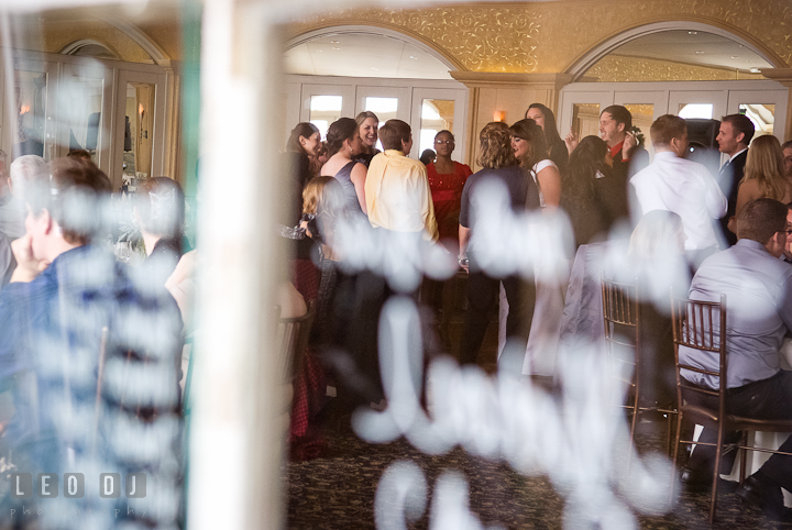 Guests dancing seen through a window. The Ballroom at The Chesapeake Inn wedding reception photos, Chesapeake City, Maryland by photographers of Leo Dj Photography.