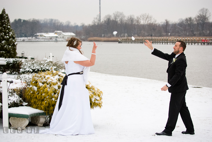 Bride and Groom throwing snowball at each other. The Ballroom at The Chesapeake Inn wedding reception photos, Chesapeake City, Maryland by photographers of Leo Dj Photography.