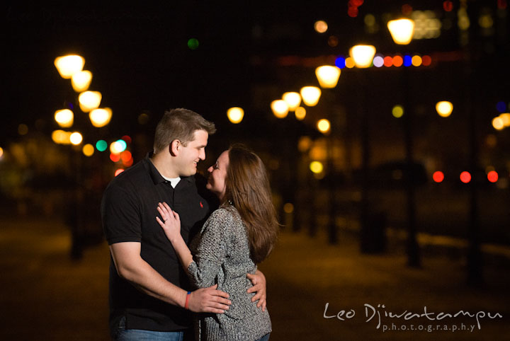 Engaged couple embracing each other in the evening. Fells Point Baltimore Maryland pre-wedding engagement photo session with their dog pet by wedding photographers of Leo Dj Photography