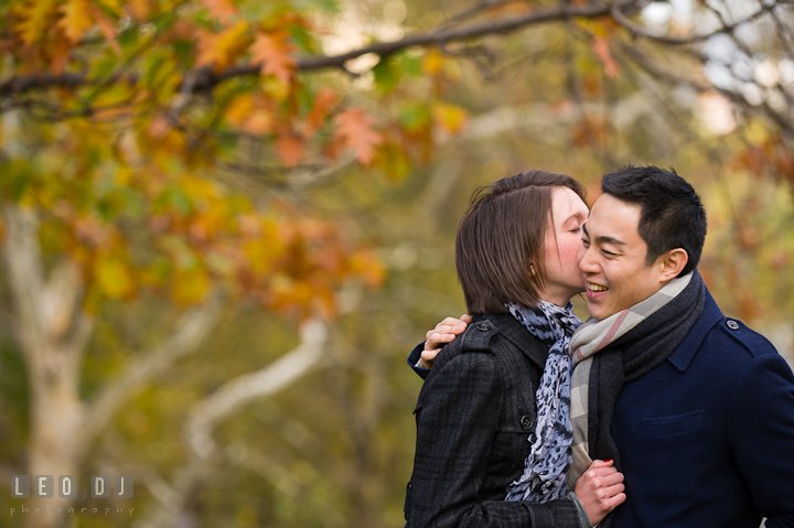 Engaged girl kissing her fiancé at Central Park. Pre-wedding engagement photo session at New York City, NY, by wedding photographers of Leo Dj Photography. http://leodjphoto.com